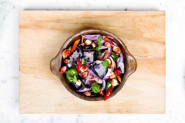 colorful salad in a bowl on a cutting board