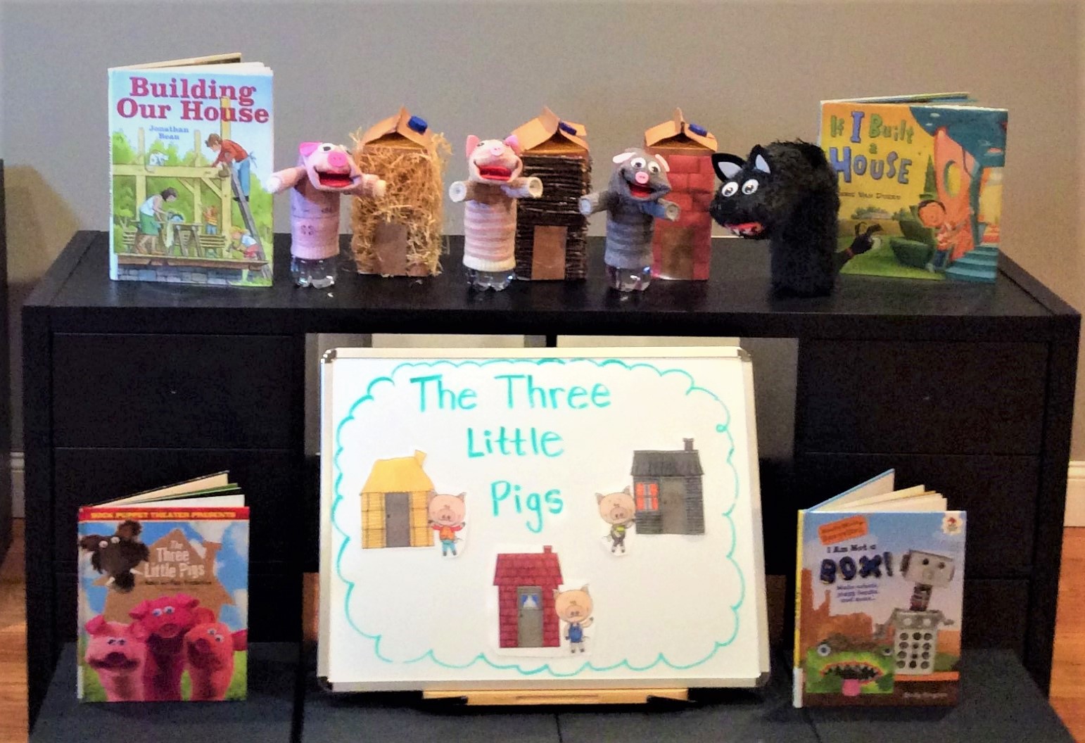 three little pigs written on whiteboard books display three pigs and wolf puppet