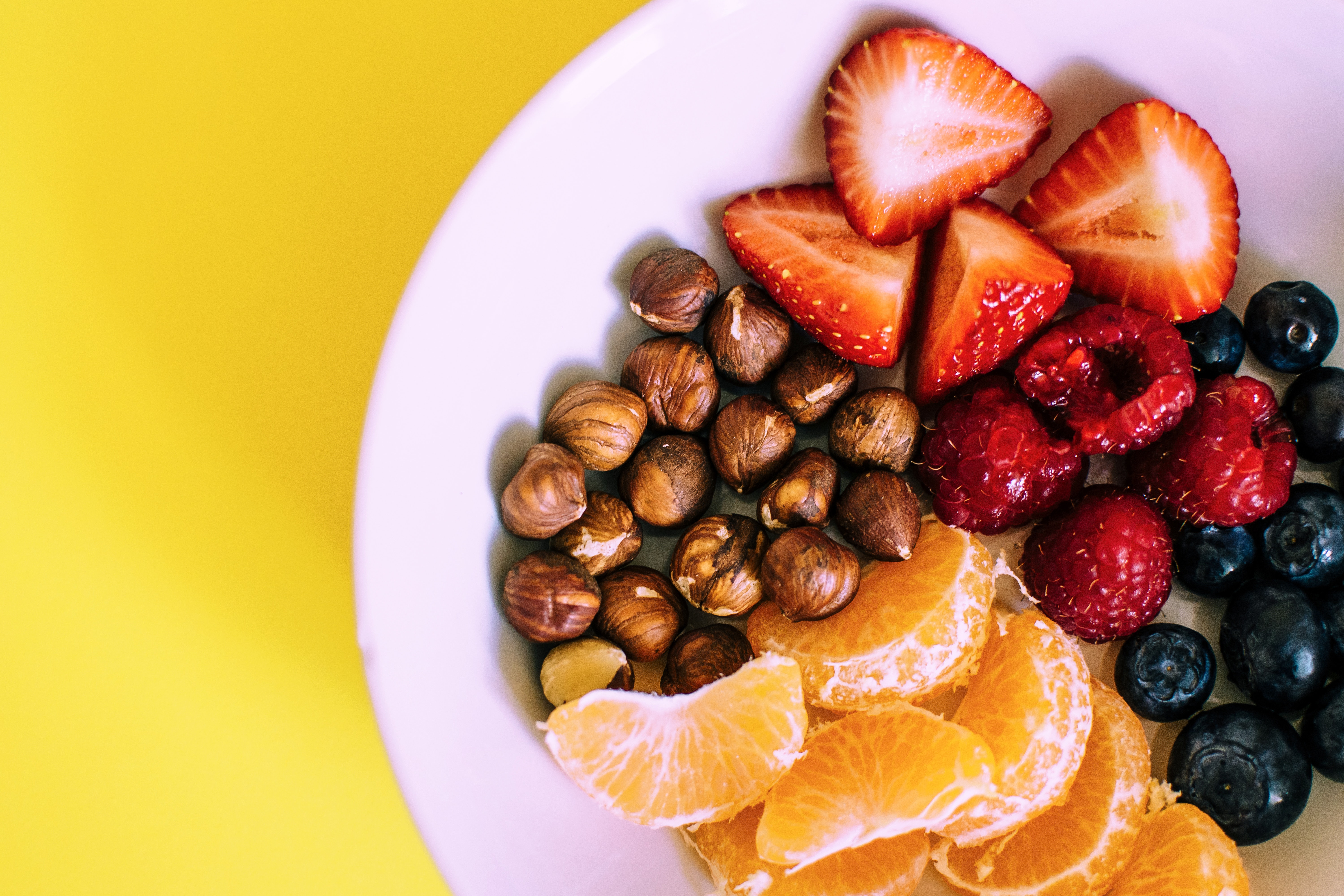 Plate with chestnuts, blueberries and  slices of oranges and strawberries.