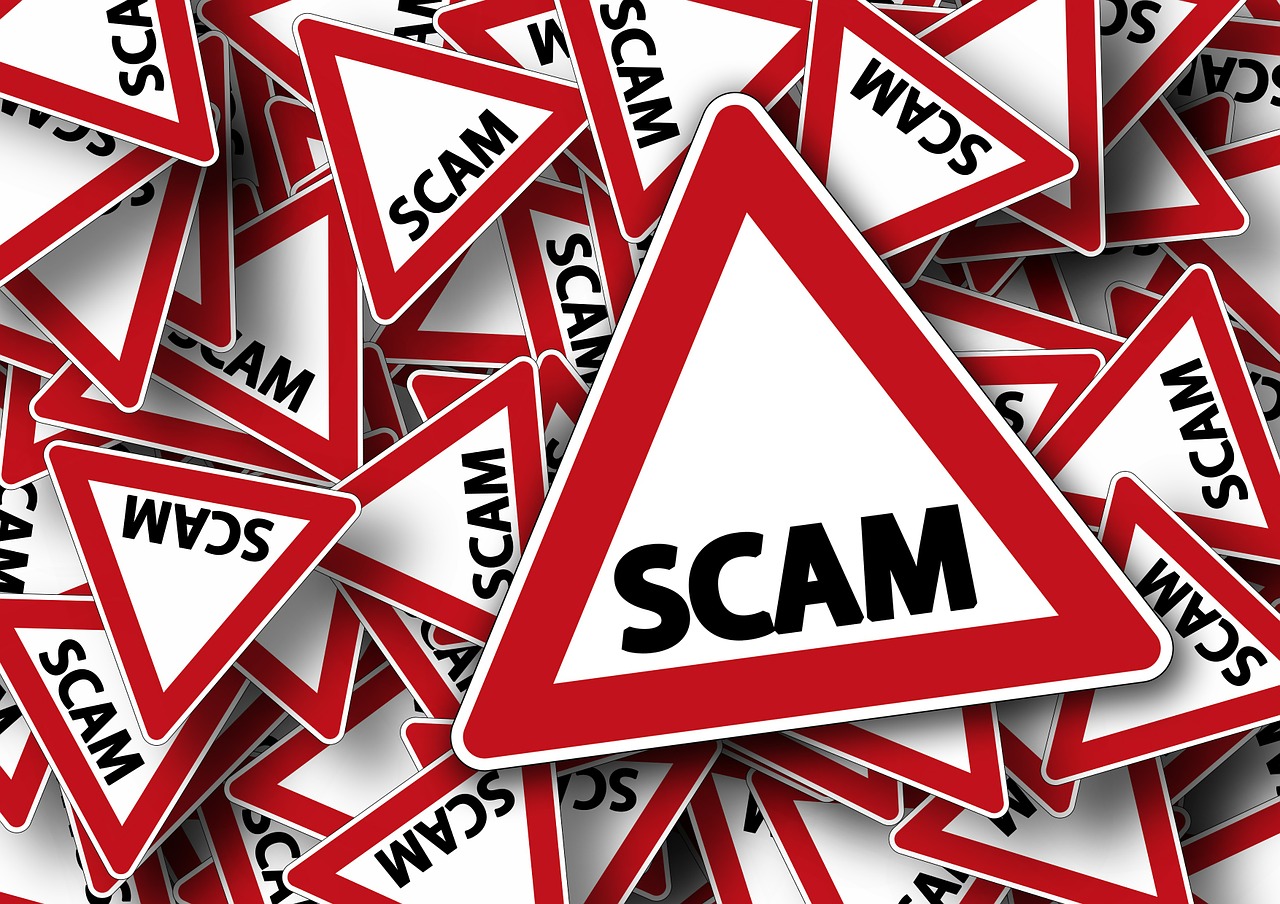 pile of triangular signs that say SCAM