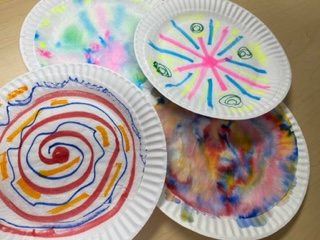 coffee filters with colorful marker scribbles on paper plates 