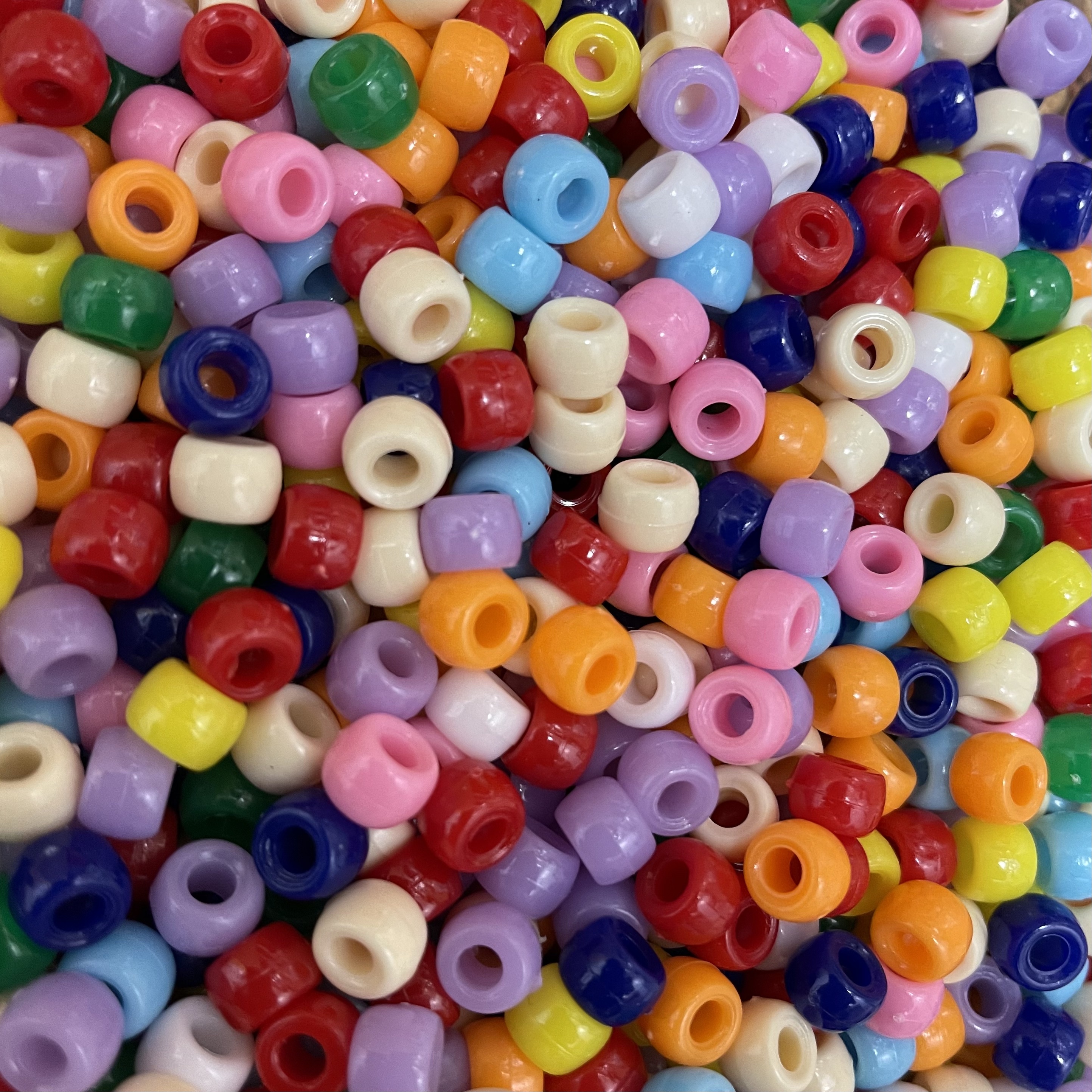 a large assortment of colored pony beads in a pile