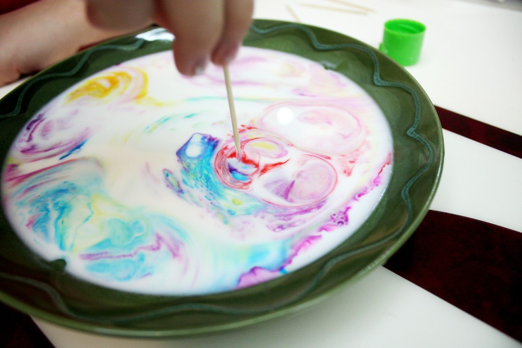 bowl of milk with various colors of dye floating on top