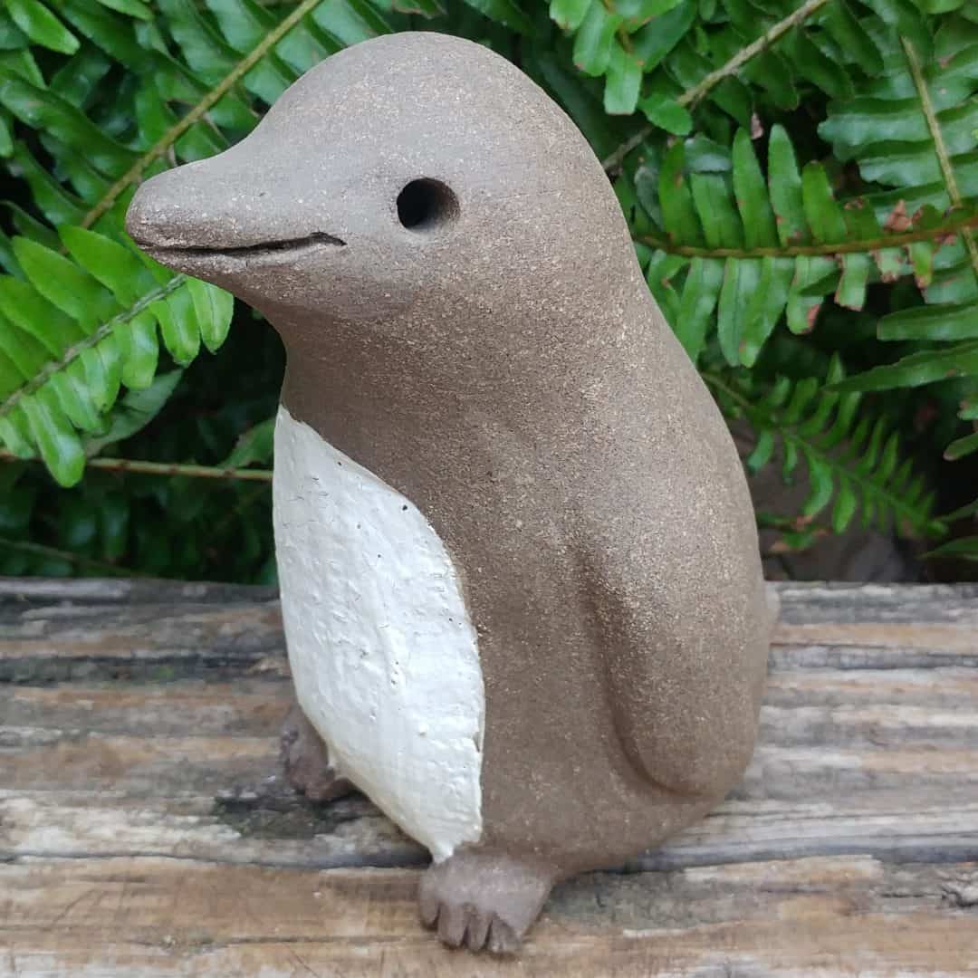 a simple clay penguin with a happy face