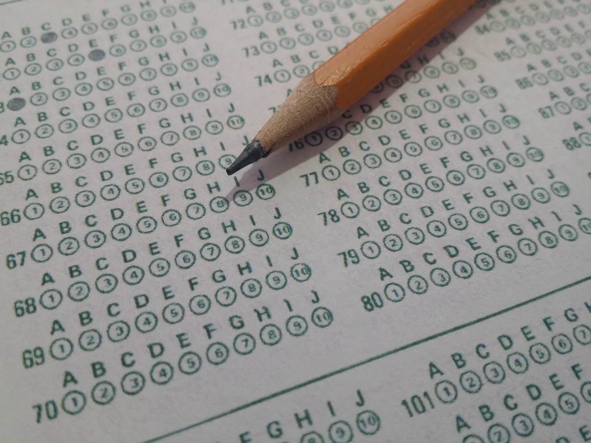 sharpened pencil laying on top of a standardized score sheet
