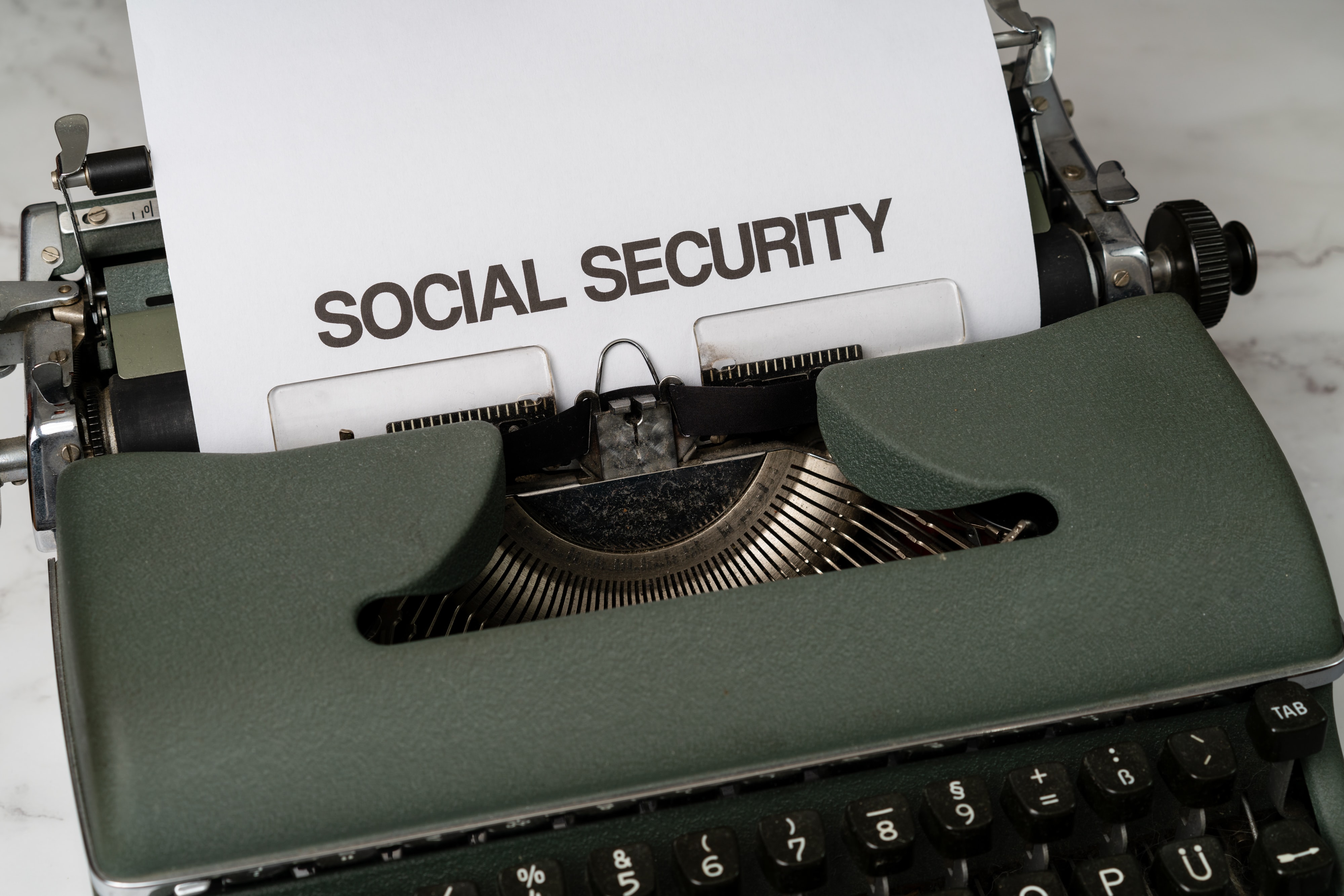 A typewriter has a page inserted with the words "Social Security" across the top.