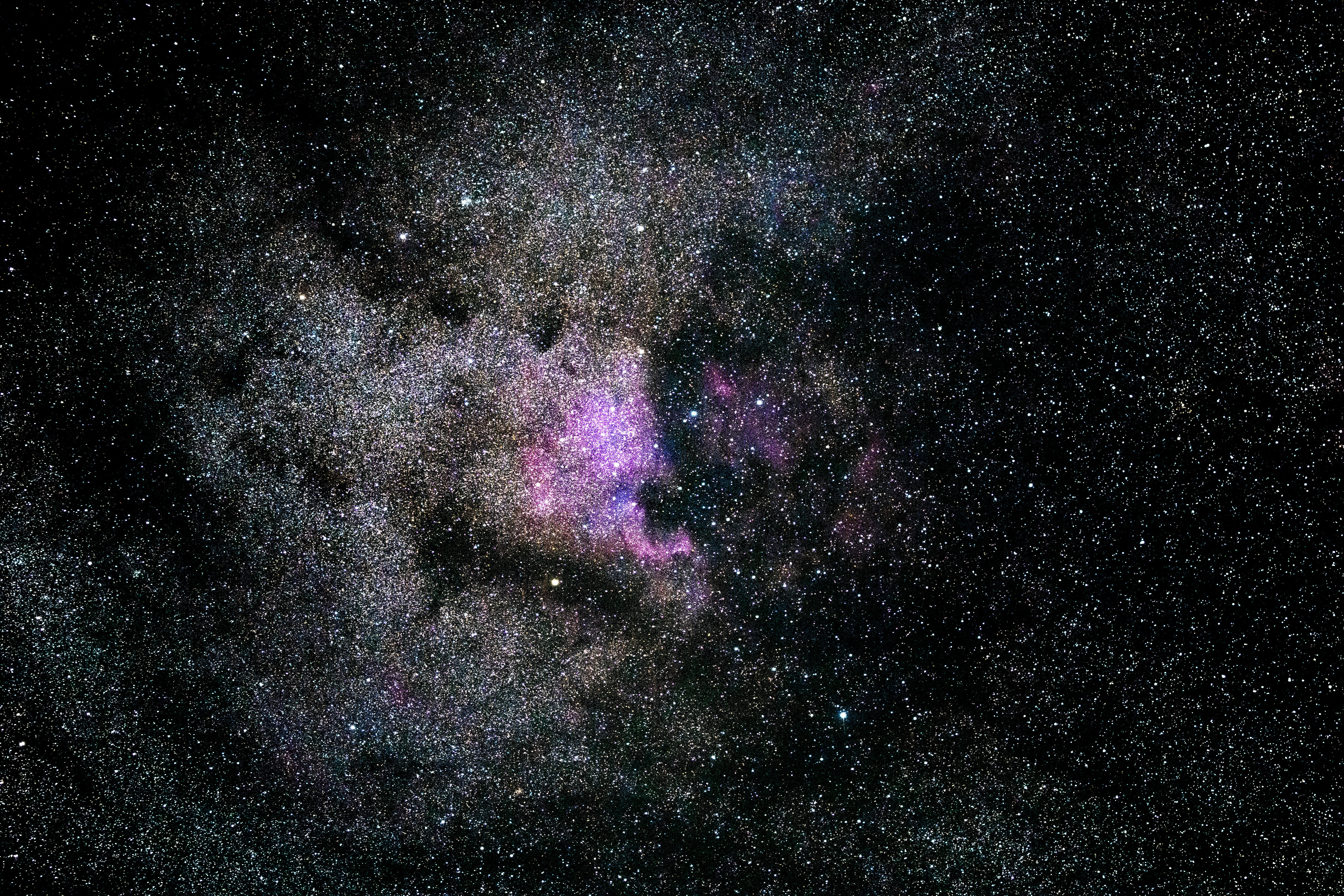 Photo of galaxy with black cosmos and central purple light.