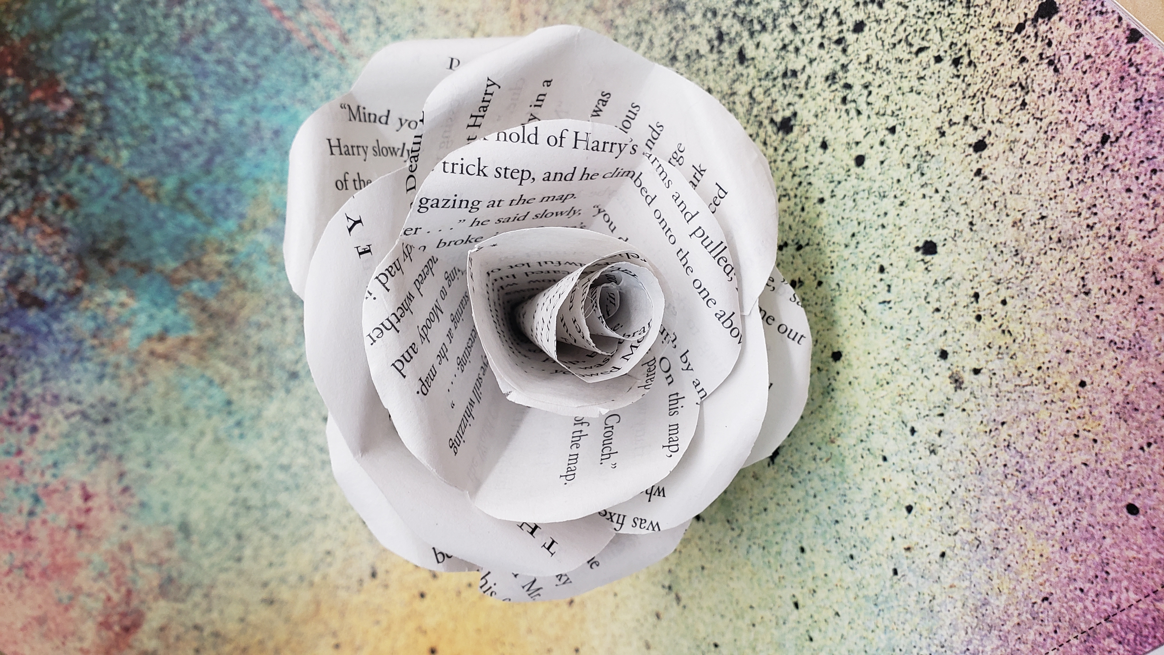 paper rose is shown with book page text
