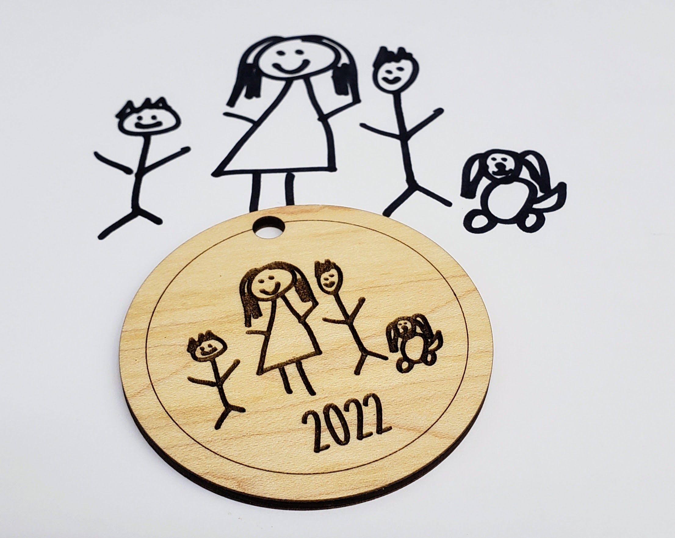 Family drawing engraved into wood with the text 2022