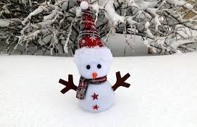 snowman in snow with tree in background