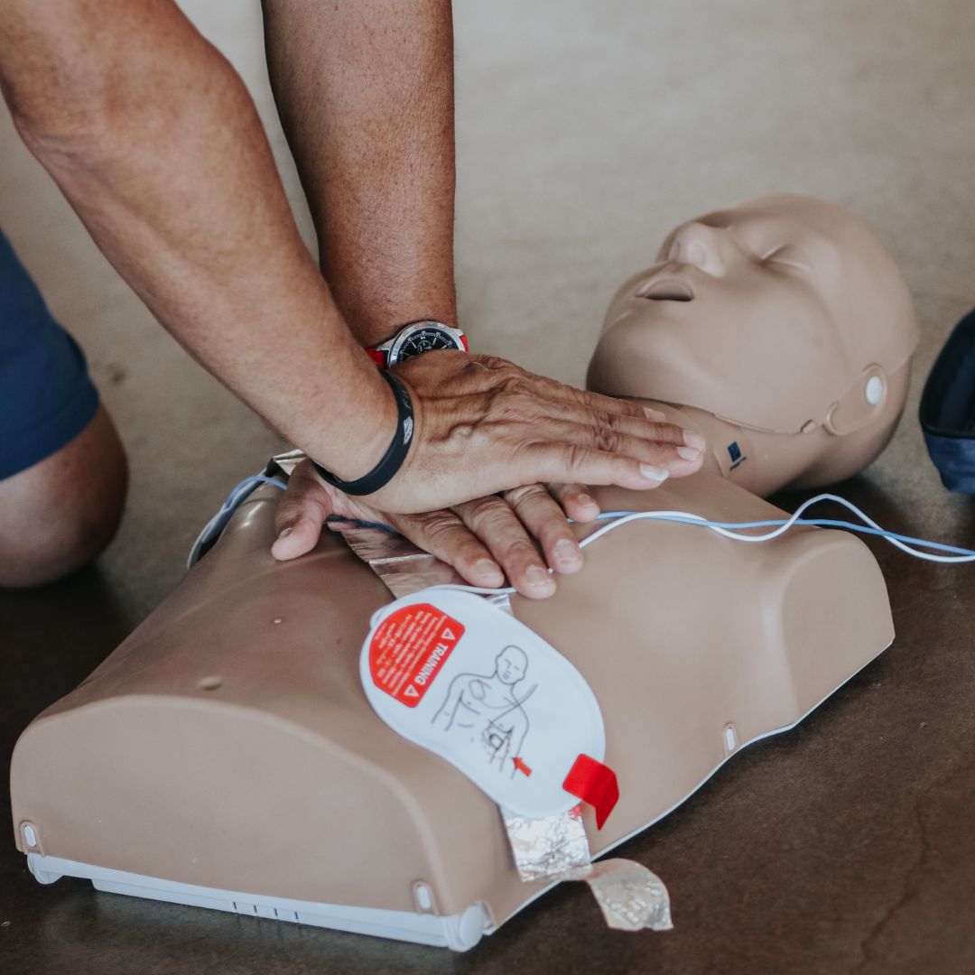man performing cpr on dummy