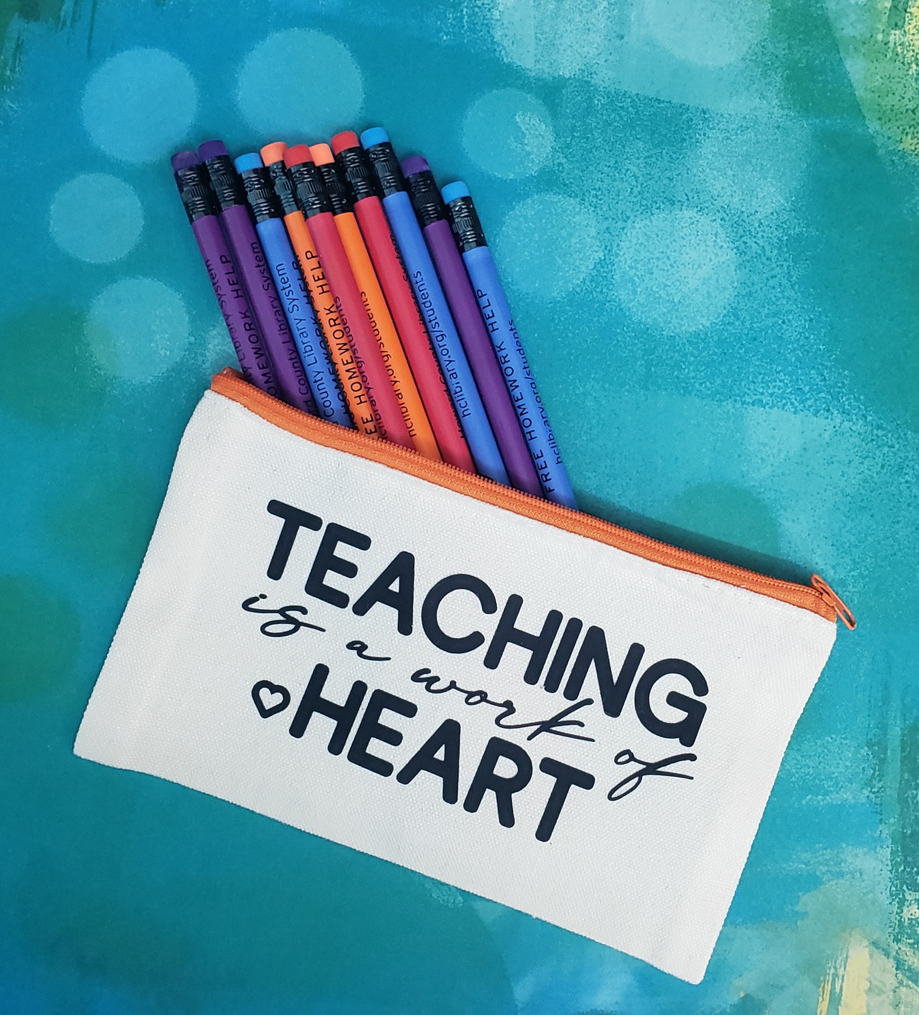 pencil bag with pencils and saying "Teaching is a work of heart"