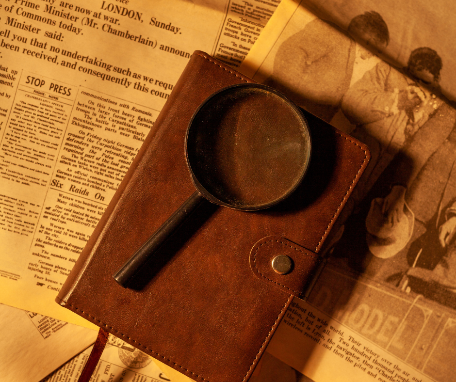 Magnifying glass and leather journal resting on historical documents