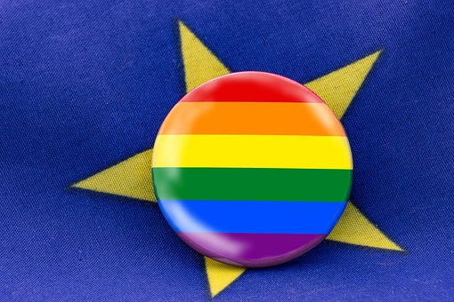 Rainbow button over a navy background with a gold star
