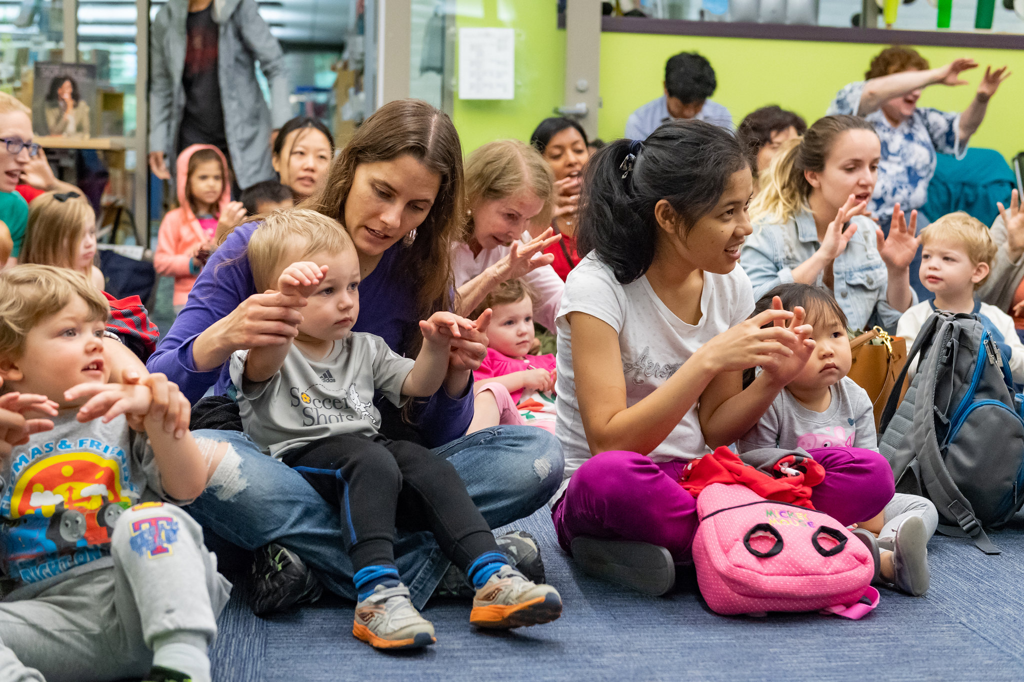 Group of young children with adults participating in a storytime class.