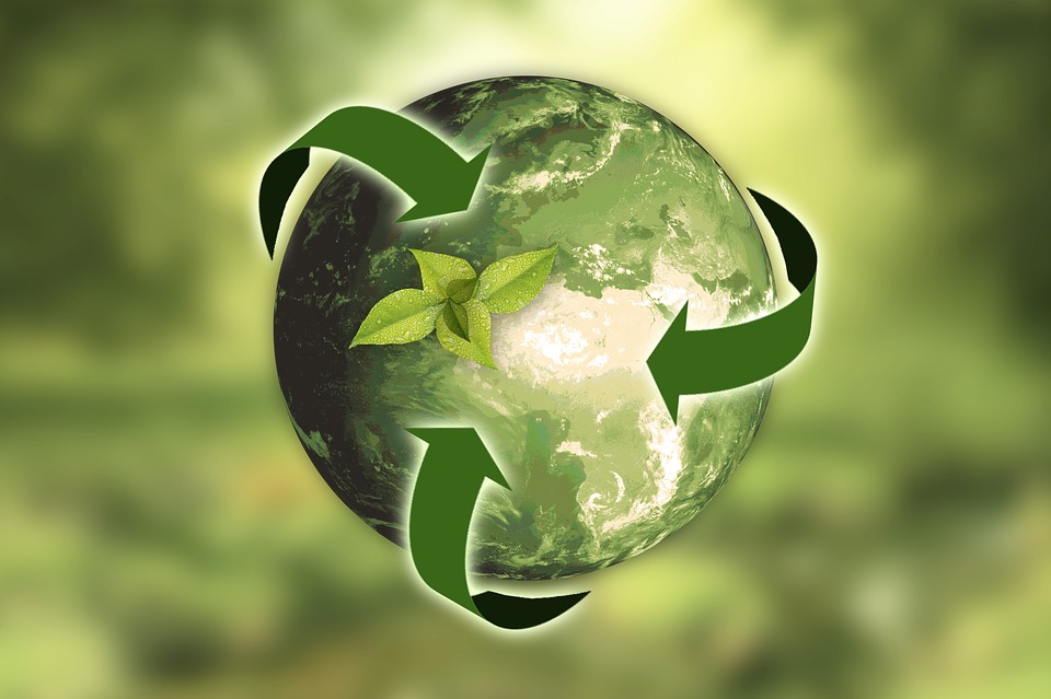 green earth with recycling icons against green background