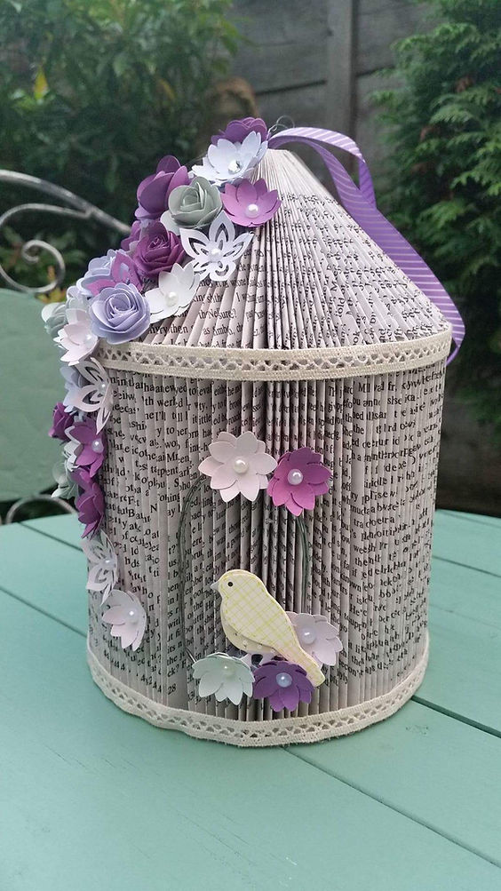 Birdcage made of an upcycled book with lace trimming and paper flowers and birds.