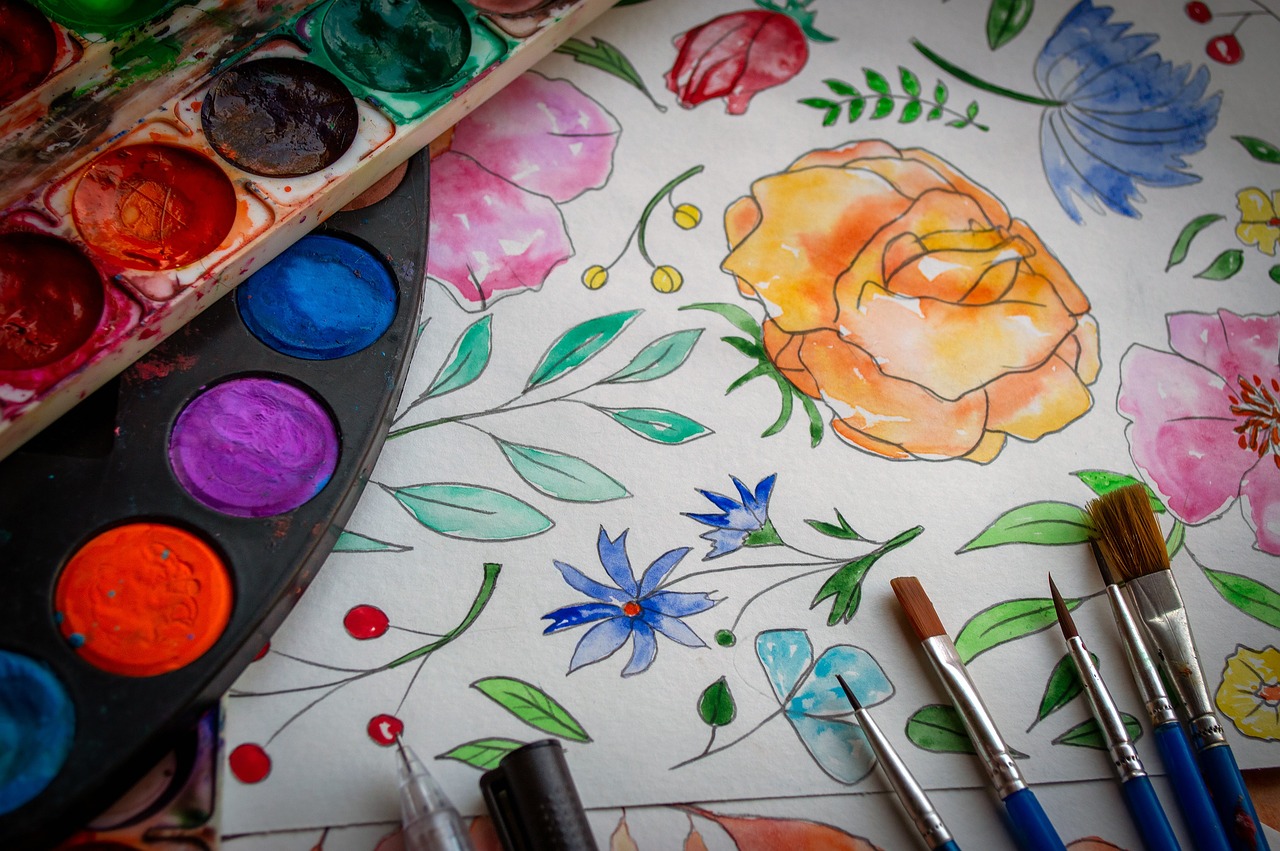 watercolor paints, brushes and picture with watercolor flowers