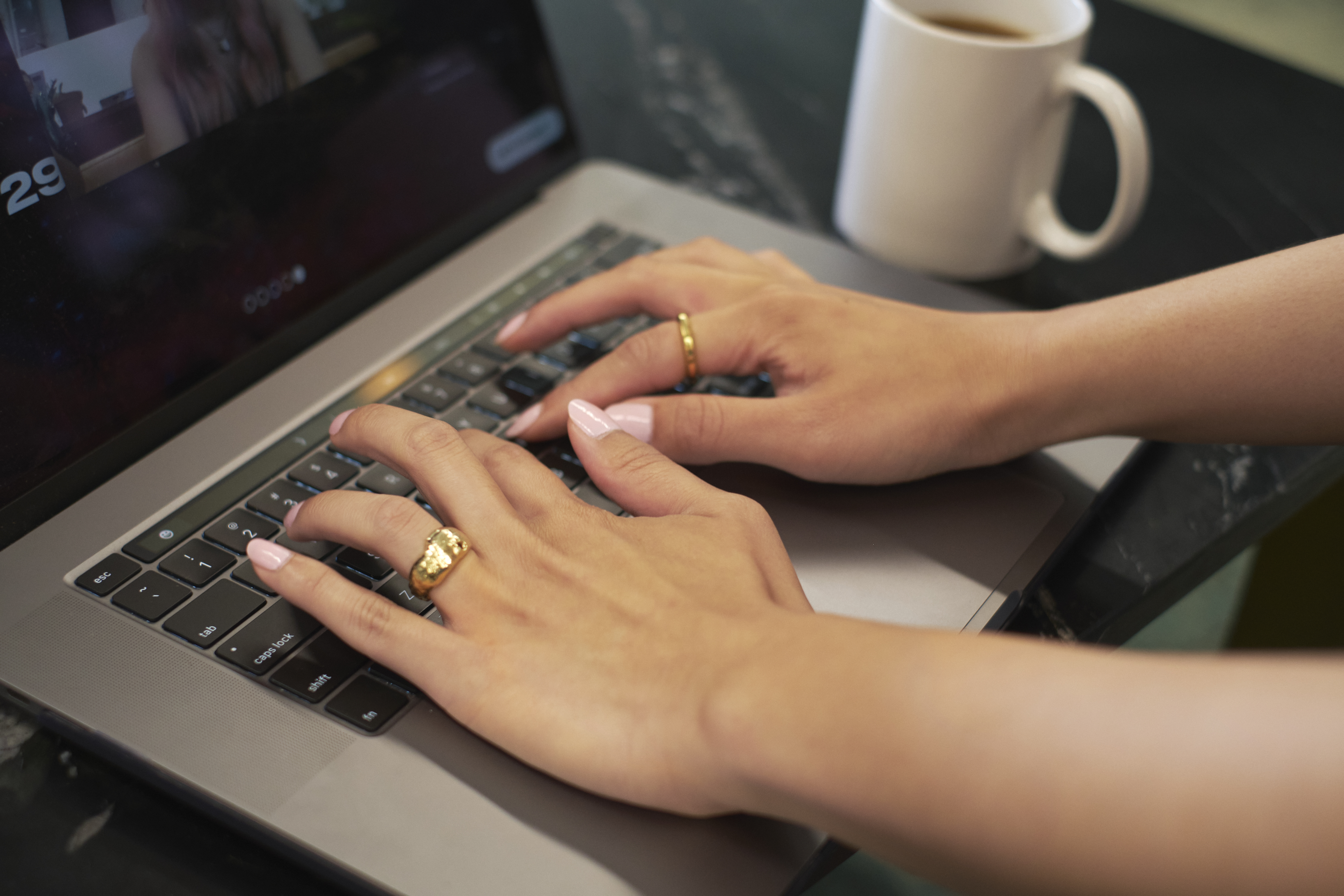 close up of a trans-feminine person using a laptop keyboard