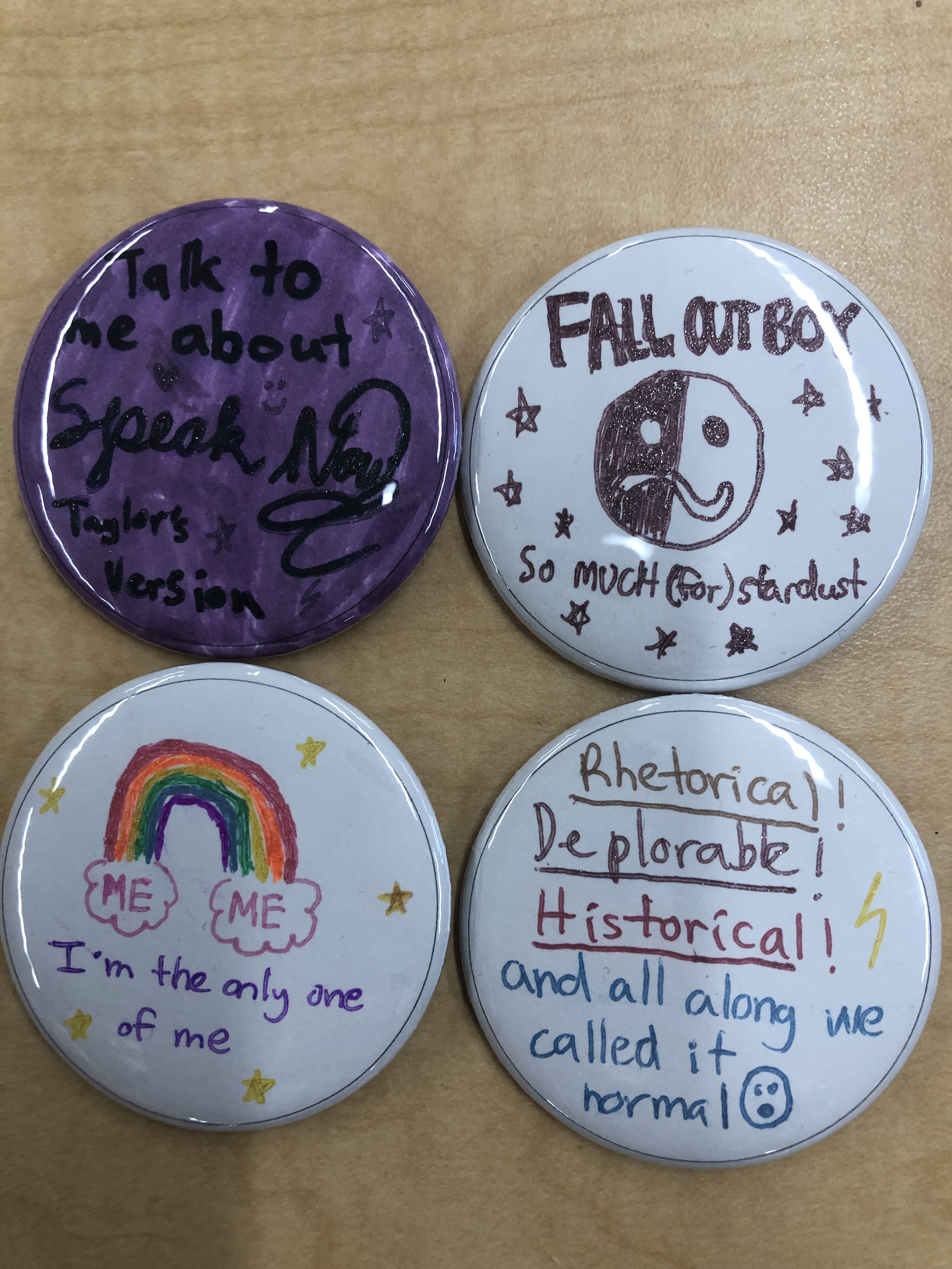 4 homemade buttons featuring band names and inspirational messages