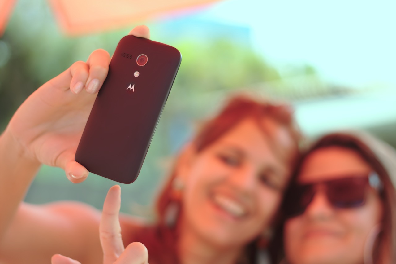 Image of woman taking selfie with smartphone