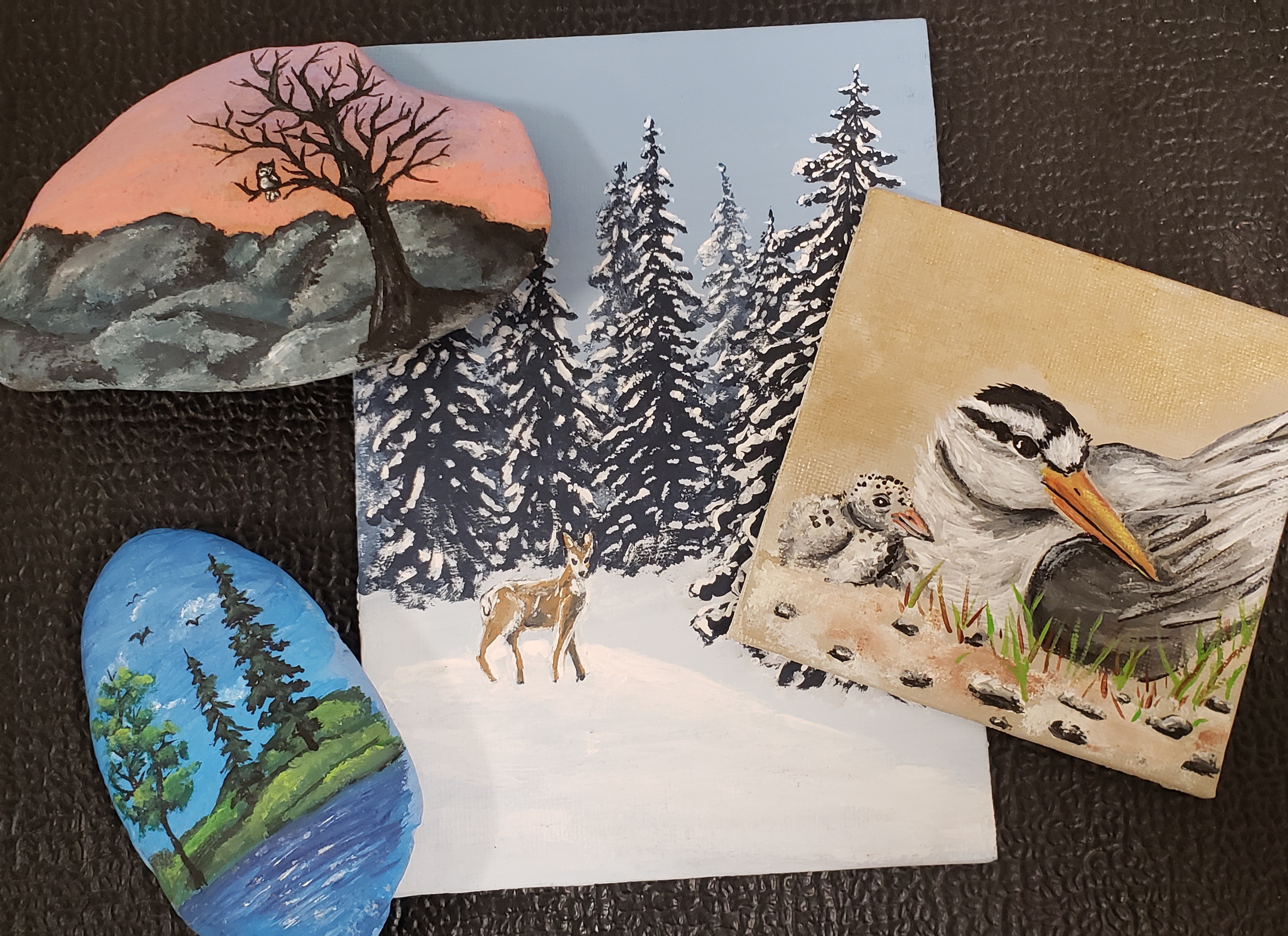 a selection of miniture paintings on canvases and rocks