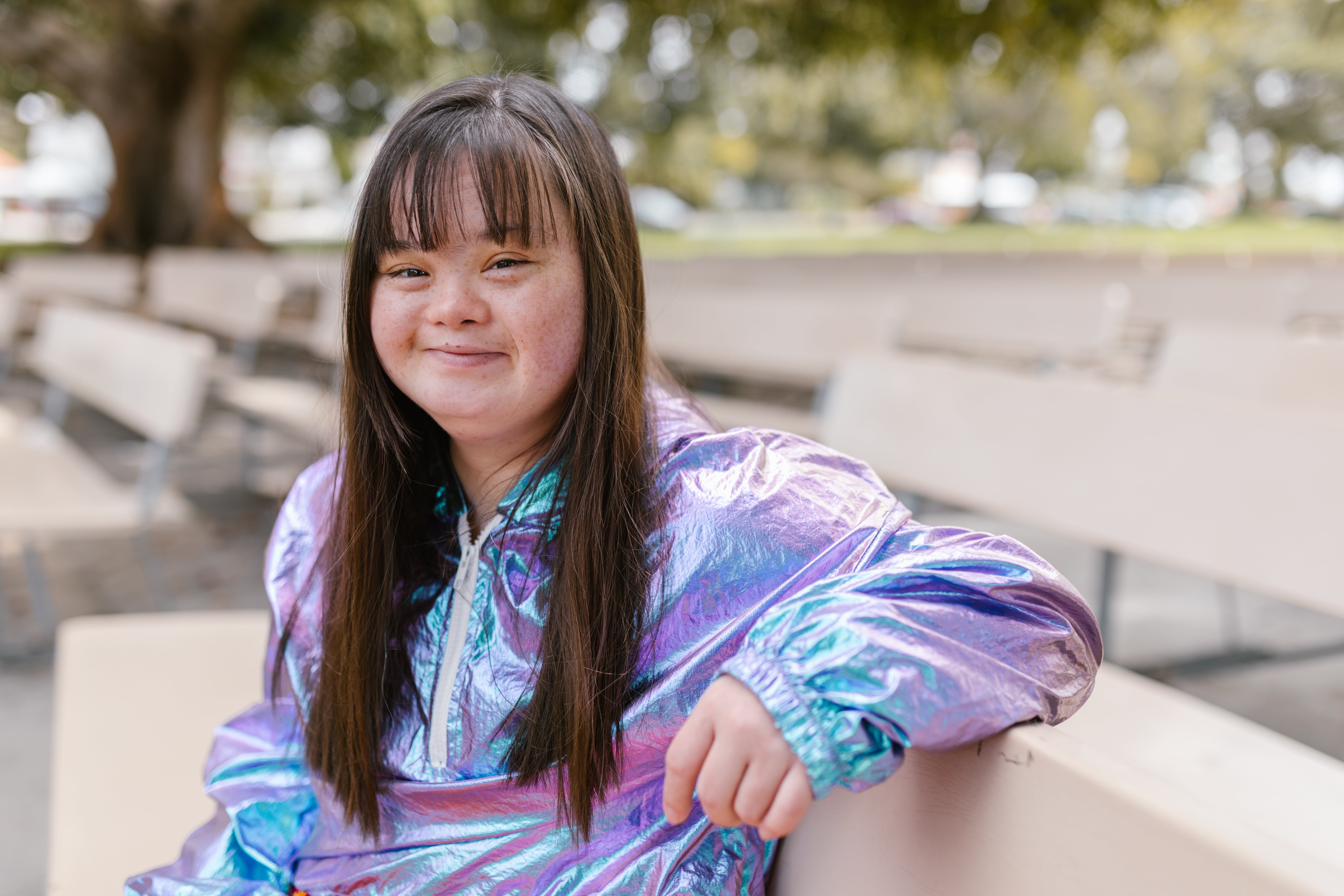 Teen girl with Down Syndrome sitting on bench
