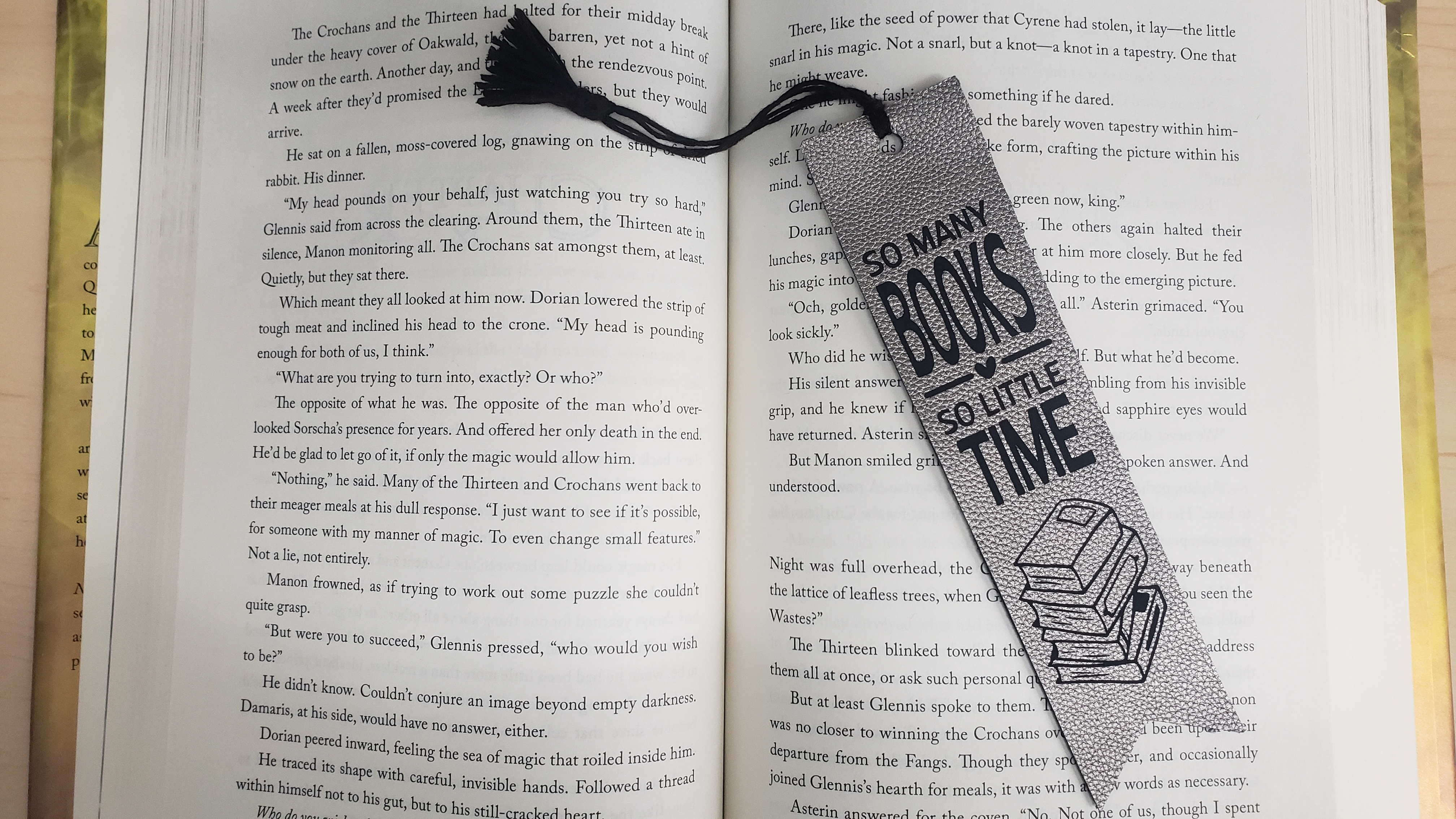 Bookmark on open book reads "So many books, so little time"