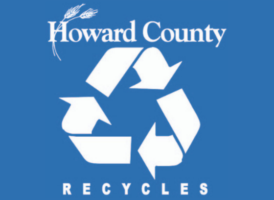 Blue background with white letters reading"Howard County Recycles" with recycling symbol