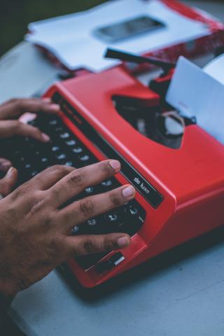 hands typing on old fashioned typewriter