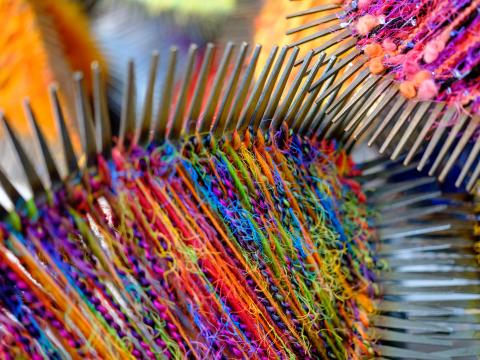 rainbow colored yarn wrapped around spiky object designed by artist Virginia Sperry