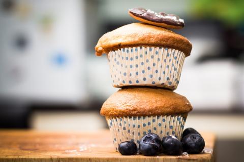 stack of golden muffins next to a pile of blueberries