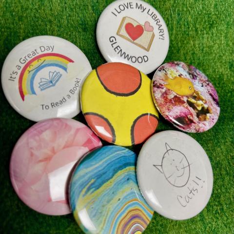 a variety of colorful pins made using the button machine at the Glenwood branch