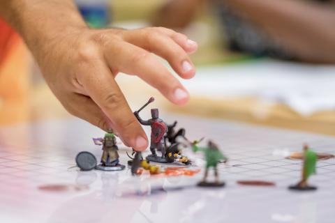 D&D figures being moved around by a hand