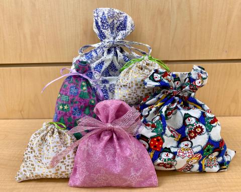 a cluster of fabric gift bags against a wall