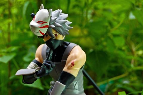 a figurine of Kakashi Hatake in front of a foliage