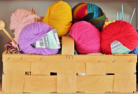 balls of colorful yarn in a tan basket