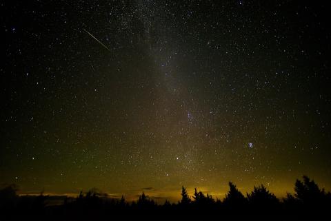 This image displays a night sky full of stars with a few shooting stars or meteors pictured.