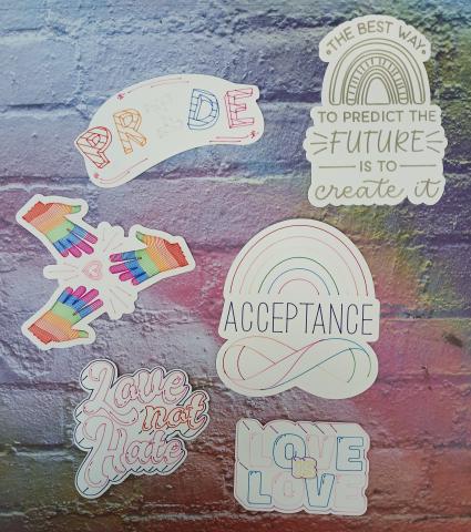 Stickers with messages of Prode, Love not hate, and Acceptance shown on a multicolored background