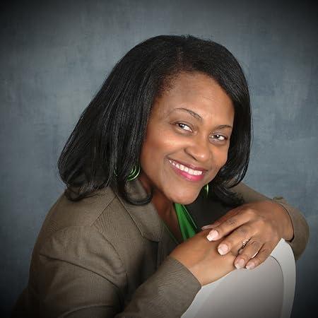 Black woman with shoulder length dark hair, smiling, with gray background