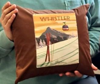 a brown cloth pillow with a printed image of Whistler on the front