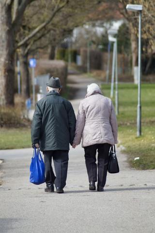 Older couple walking holding hands