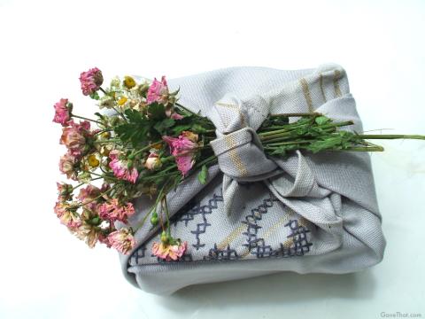 Vintage-napkin-cloth-wrapped gift with dried flowers tucked into the knot