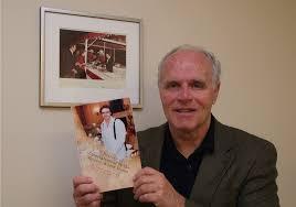 Alan DeValerio holding up a copy of his book