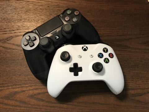 a black video game controller and a white one