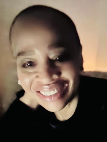 Image of headshot of Adar Ayira. Wearing black shirt, smiling. 