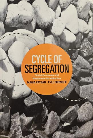 Book Cover of Cyle of Segregation. The cover is a close up image of large rocks, with white rocks at the top and dark grey rocks at the bottom. The book's title appears in an orange circle in the center of the image. 