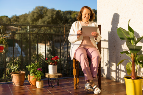 photo of woman sitting outside using a computer tablet