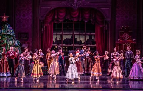 KCB School Students and Natalia DaSilva as Clara in the Nutcracker. Dancers hold dolls, Clara hold the Nutcracker. 