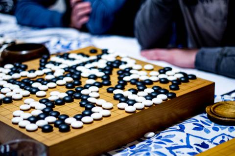 Go board with stones and players